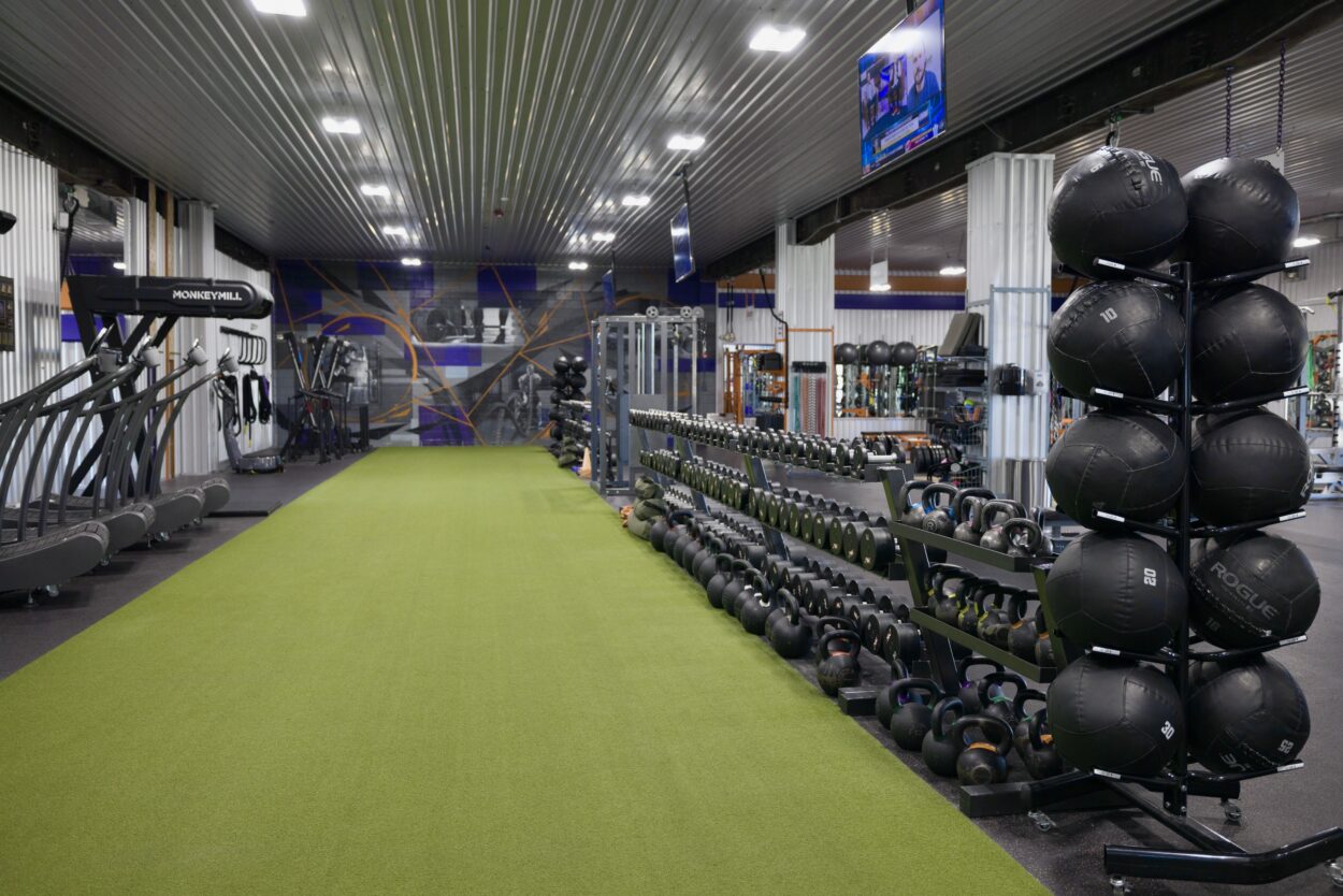Gym turf area and equipment used for mobility work, training, and recovery exercises