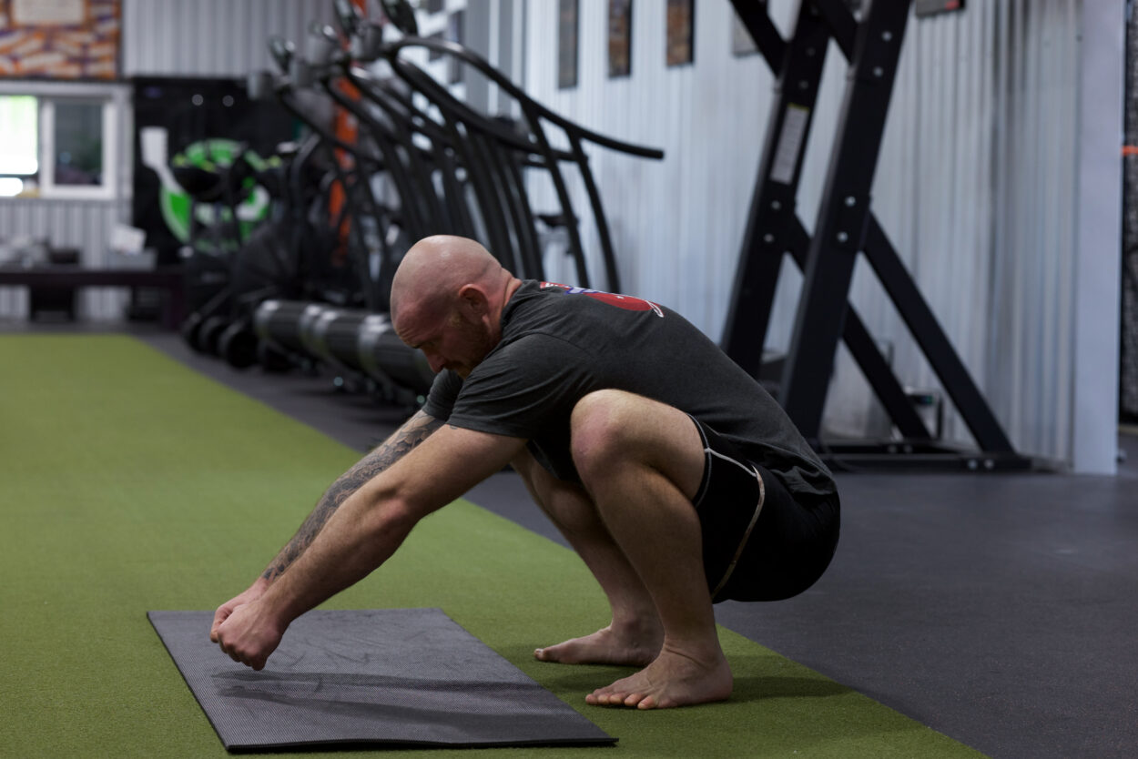 Jiu-jitsu athlete in a deep mobility stretch demonstrating selective tension and mobility training