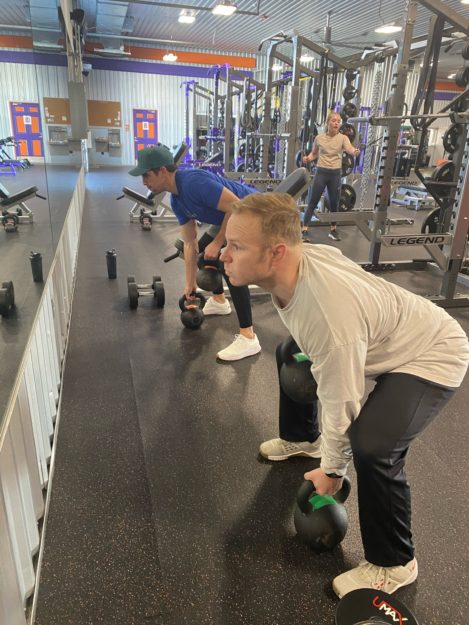 man in a deadlift position getting ready to pick up a kettlebell
