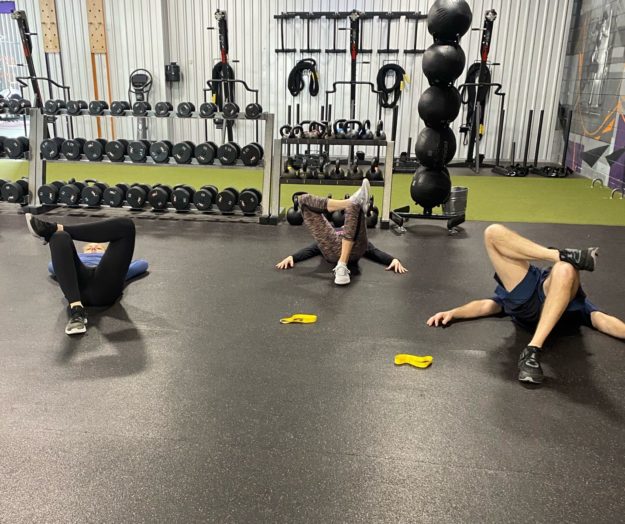 people stretching on the ground during a workout class